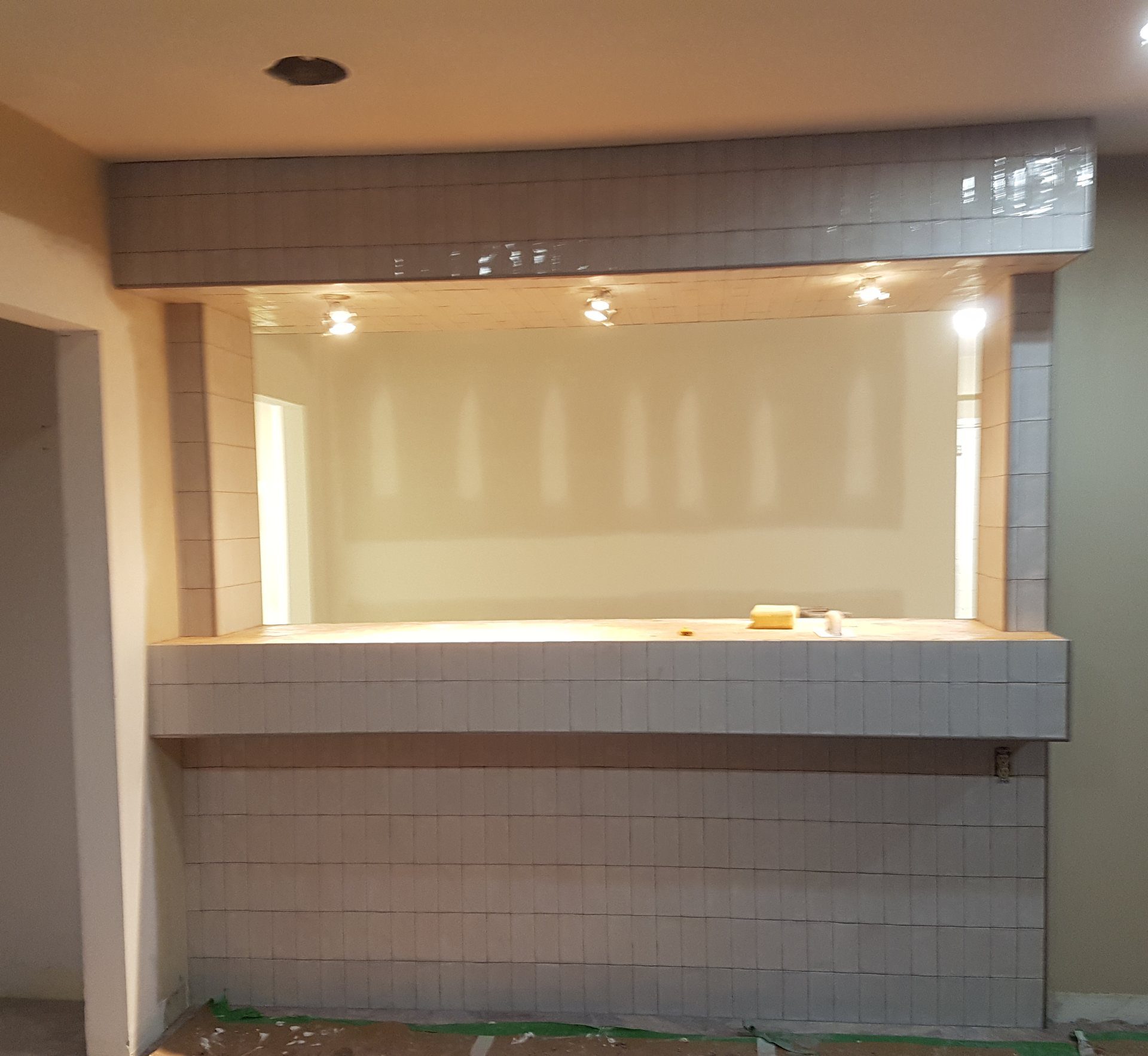 Bar pass-through with the counter, the front and the bulkhead above all finished in grey tile